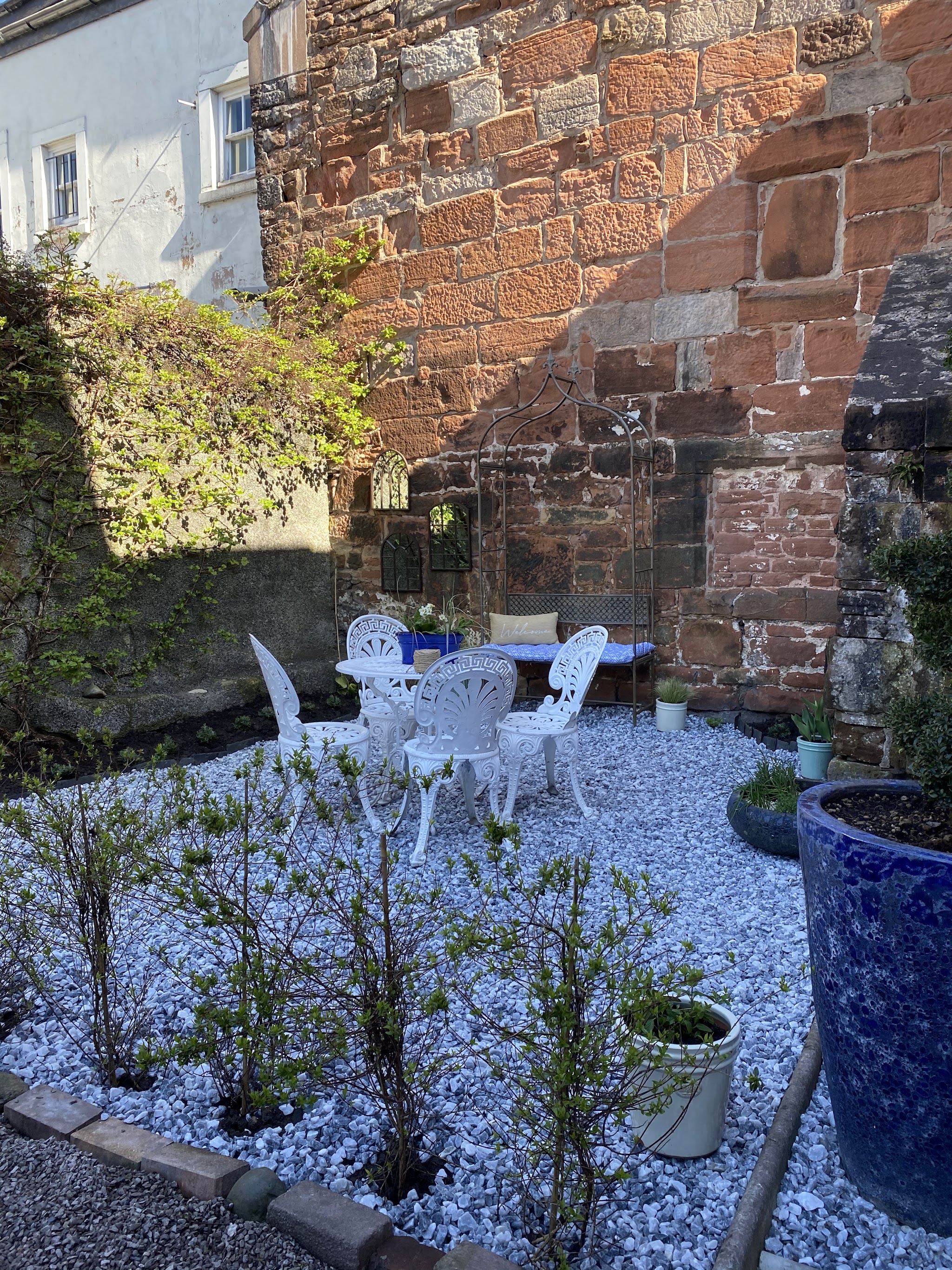 The courtyard garden with white wrought iron table and chairs