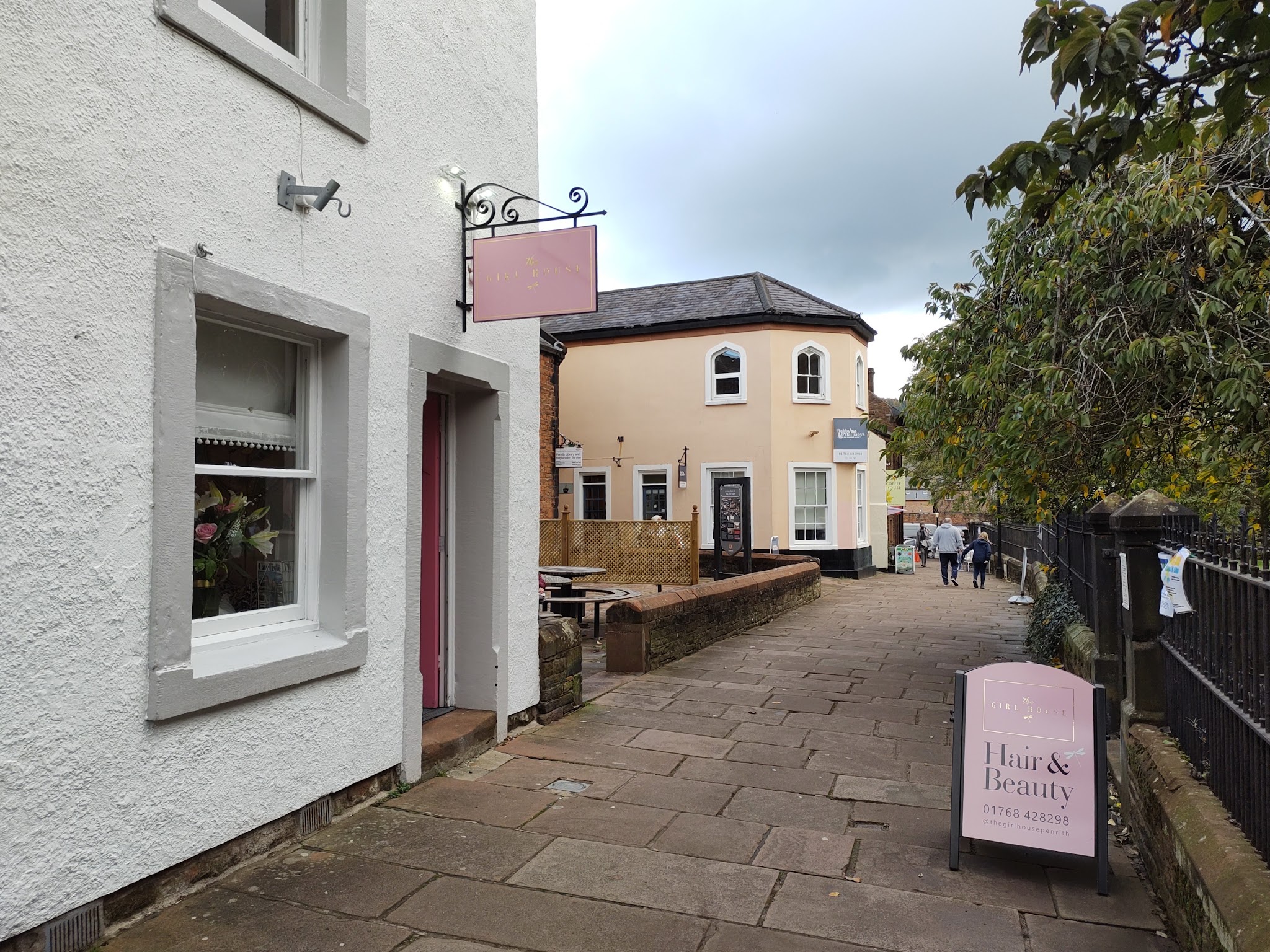 The lane leading to The Girl House, with its pink sign and A-board